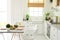 Modern bright white kitchen interior with wooden and white details. Healthy breakfast with fruits and salad on the