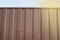 Modern brown metal corrugated siding fence, outdoor winter space, safety and security, veneer texture