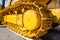 Modern bulldozer tracks and drive gear, large yellow construction machine, heavy industry