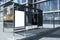 Modern bus stop with empty white mock up poster in creative city with glass buildings and reflections. Contemporary street. 3D