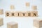 Modern business buzzword - driven. Word on wooden blocks on a white background