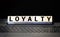 Modern business buzzword - loyalty. Word on wooden blocks on a white background