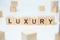 Modern business buzzword - luxury. Word on wooden blocks on a white background