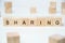 Modern business buzzword - sharing. Word on wooden blocks on a white background