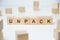 Modern business buzzword - unpack. Word on wooden blocks on a white background