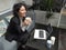 Modern business caucasian woman smiling, sitting on the sofa with a laptop and grabbing a cup of coffee