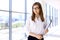 Modern business woman standing and keeping papers in the office with copy space area