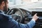 Modern businessman. Side view of young bearded businessman in formal wear is touching control panel while driving his