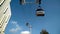 Modern cable car with cabins on blue sky background. Action. Beautiful cable car with modern cabins and beautiful design
