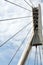 Modern cable-stayed bridge pillar with steel ropes closeup view