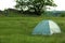 Modern camping tent in green field. Space for