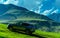 Modern car on a green hill in a picturesque mountains valley