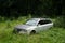 Modern car, vehicle and automobile is abandoned and deserted in high overgrown grass