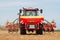 Modern case tractor drilling seed in field with vaderstad drill
