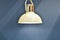 Modern chandelier hanging on wall background. Subdued light of lamp in evening in room. Shadows on  wall. pendant lamp