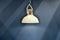 Modern chandelier hanging on wall background. Subdued light of lamp in evening in room. Shadows on  wall. pendant lamp