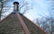 Modern chimney on the shingles wooden roof of house.