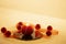 Modern Christmas copy space: close up of a red lit candle with cross screen effect on a limestone plate surrounded by red baubles