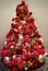 Modern christmas tree of red flowers. Scarlet peons, golden rabbits and shiny balls. Christmas and New Year