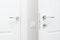 Modern chrome door handle and lock with key. White interior door