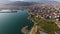 Modern city architecture on a seashore with spectacular mountains, drone view