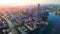 Modern city with canal on background of setting sun. Stock footage. Top view of beautiful panorama of modern city with