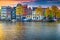 Modern cityscape and water canal with houseboats in Amsterdam, Netherlands