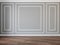 Modern classic gray interior blank wall with moldings and wood floor.