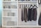 Modern closet with row of pants hanging in white wardrobe