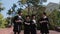 In modern college garden group of multiracial students graduates walking down the stairs while holding diplomas in hands