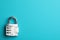 Modern combination lock on light blue background, top view. Space for text