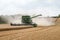Modern combine harvester cutting crops corn wheat barley working golden field
