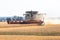 Modern combine harvests a wheat field