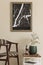 Modern composition of living room interior with brown mock up poster frame, design retro chair, coffee table, vase with flower.