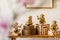 Modern composition of stylish accessories, decoration, flowers, gold monkey on the wooden bench at white living room interior.