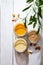 The modern concept of wellness and veganism. Jars of almond, cashew and peanut butter on a white wooden table with an olive branch