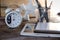 Modern conceptual wooden office or home desk table with tablet, note book, cup of pens and table clock