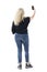 Modern cool playful middle age woman tossing smooth blond hair taking selfie with mobile phone.