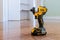 Modern cordless screwdriver, DeWalt drill with drill a wooden floor of new house for the construction