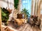 A modern cozy beautiful room with a braided rope macrame chair, green plants and a window with curtains. Interior and