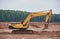 Modern crawler excavator drives through a muddy field