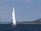 A modern cruise sailing yacht with a Bermuda sloop-type rig goes past the green coast of the Croatian Riviera on a sunny summer da