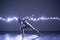Modern Dance performer dancing with a neon blue light while making gracious moves and spectacular body art expressions