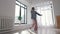 Modern dancing - a young woman dancing around the spacious empty apartment