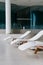 Modern deck chairs at luxury hotel. Private swimming pool for relaxation, with beautiful interior.