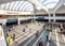 Modern design railway station with commuters in sunshine shining through dome roof