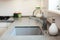 Modern designer chrome water tap over stainless steel kitchen sink