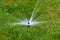 The modern device of the irrigation garden. Automatic sprinkler system of lawn watering on a background of green grass, close-up.