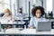 Modern devices for working in coworking office during virus outbreak. African american woman in protective mask works on