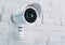 Modern digital CCTV camera on a white brick wall outdoor. IP camera security systems guard safety equipment